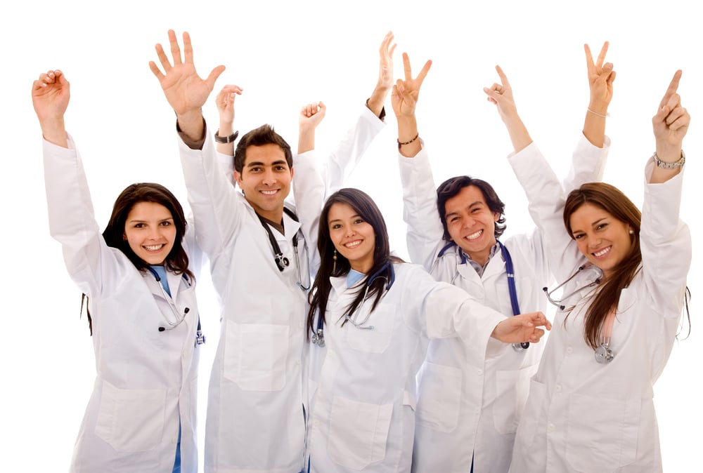 Very happy group of doctors isolated over a white background